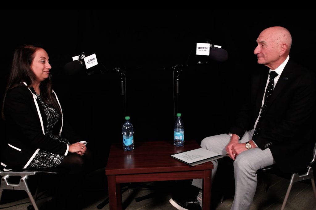 woman and man having discussion in studio setup with microphones