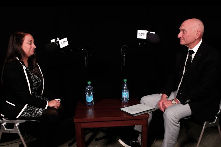 woman and man having discussion in studio setup with microphones