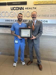 Two men stand together with a plaque