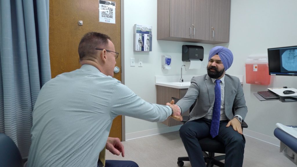 Two men shaking hands in a doctor's office