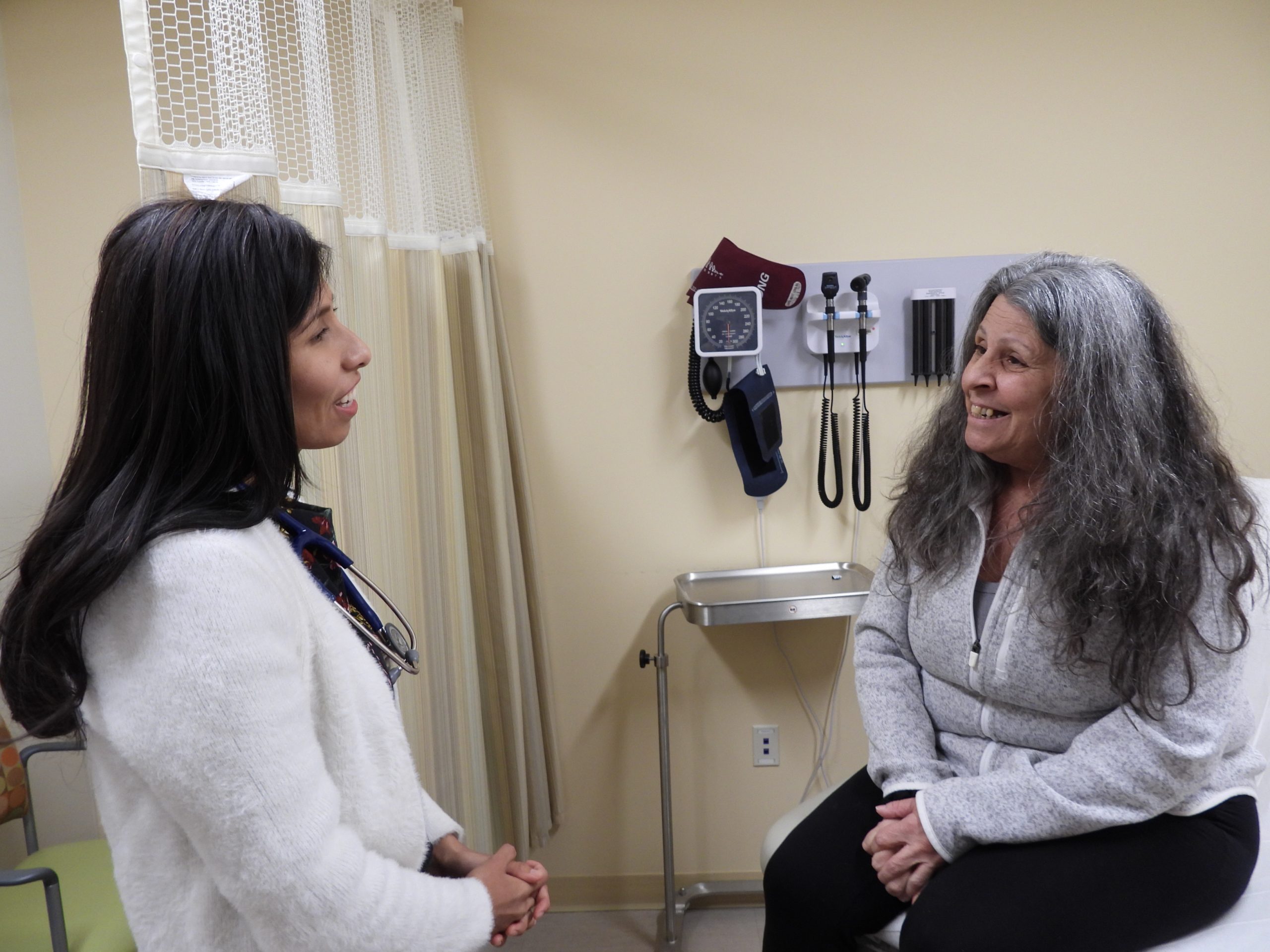Dr. Aida Roman with a happy primary care patient in exam room