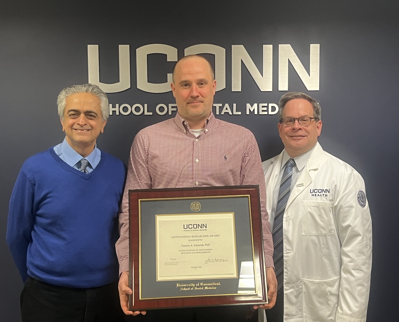 three dentists holding award