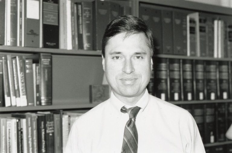 Professor Stephen Utz standing in front of a bookcase.