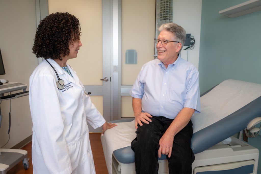 Longtime patient Mr. Robert Hoyt being cared for by Dr. Biree Andemariam in the Connecticut Bleeding Disorders Center (Tina Encarnacion/UConn Health photo).