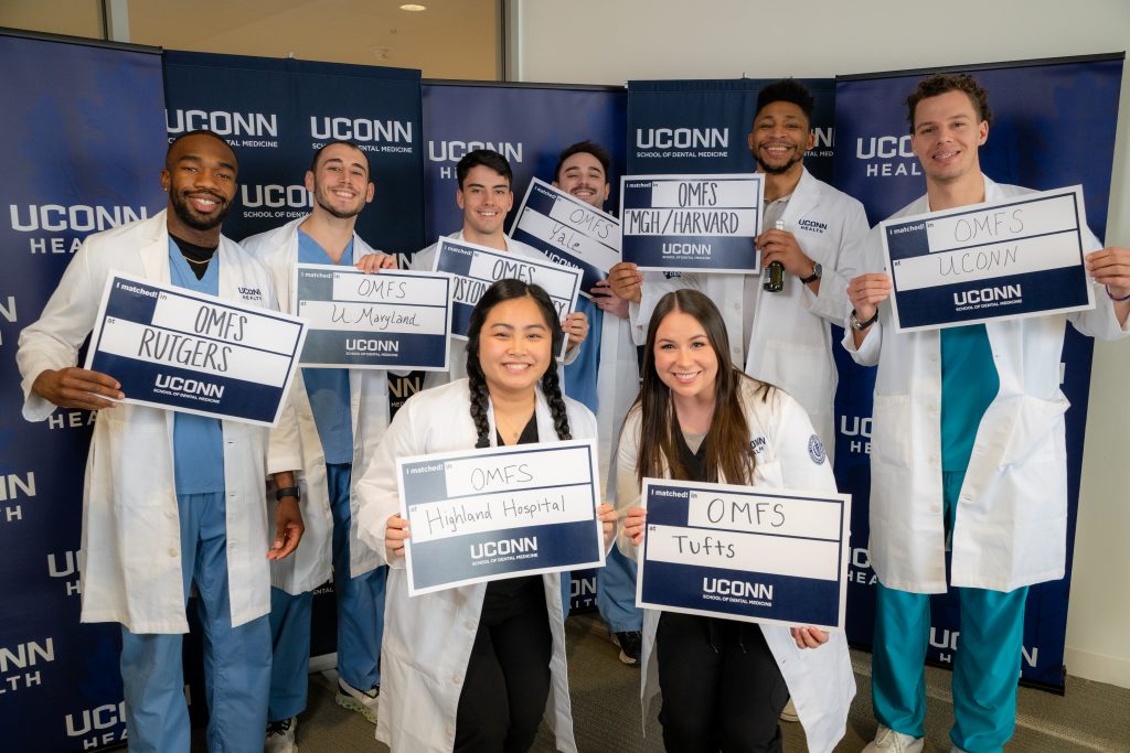 group of students pose with signns