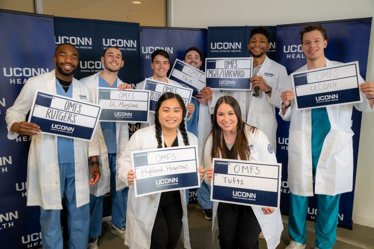 group of students pose with signns