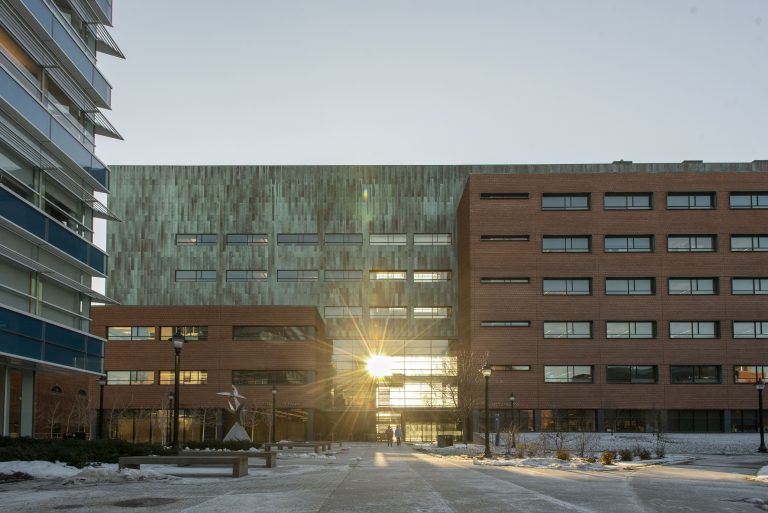 Sun set shining on the UConn Pharmacy building in the winter