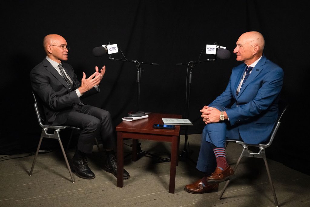 two men speaking in podcast studio