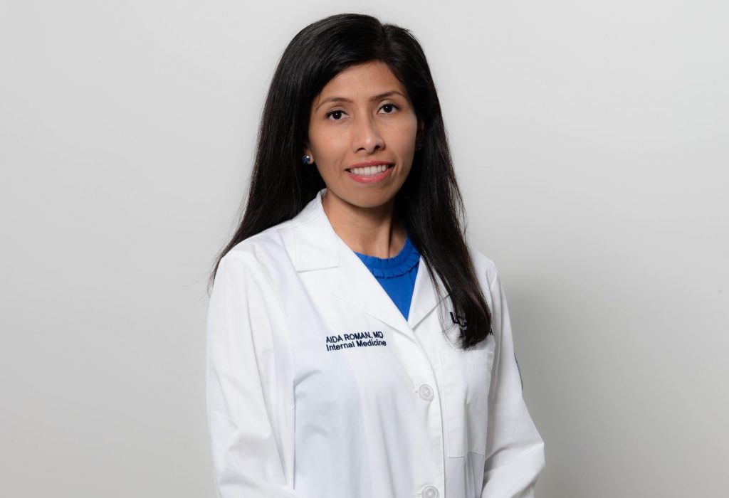Dr. Aida Roman in white coat.