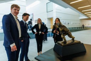 UConn students admire the Heisman Trophy.