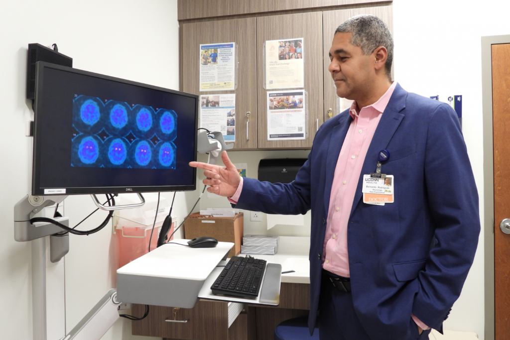 Dr. Bernardo Rodrigues of UConn School of Medicine at UConn Health's Brain & Spine Institute reviewing a patient's DaTscan.