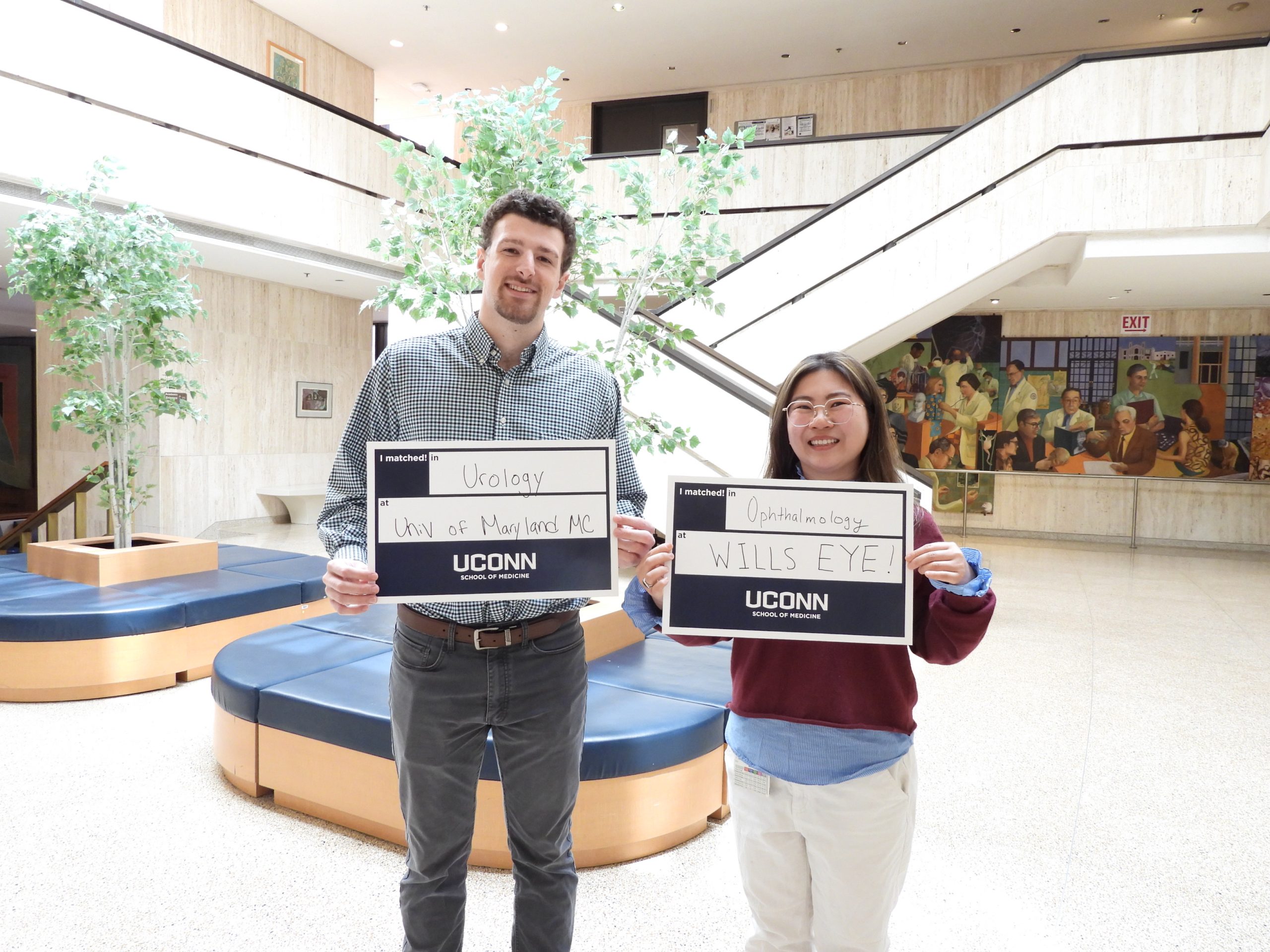 It's an early match to residency for both Kelvin Peterson and Annie Yao in the Class of 2026 of UConn School of Medicine. Holding up their match signs.