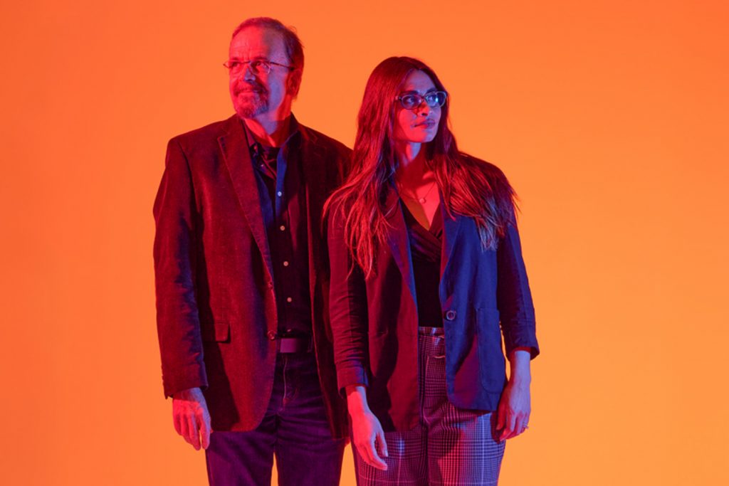 Jordan Ochs (FYE Program Director), and Bradley Wright (Professor of Sociology) stand tall against a gradient backdrop of orange and pink