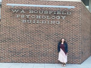 Woman standing outside of the Bousfield Psychology Building in Storrs, CT.