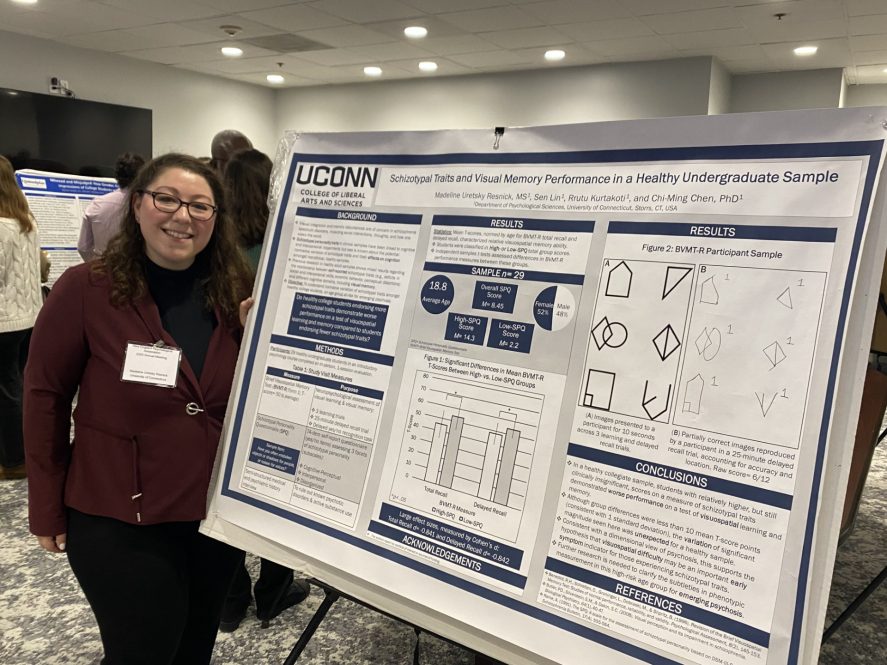 Woman standing in front of her research poster titled ""Schizotypal Traits and Visual Memory Task Performance in a Healthy Undergraduate Sample"