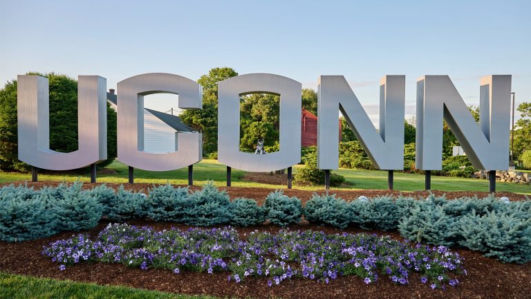 The block lettered UConn sign, with Jonathan sitting in the 