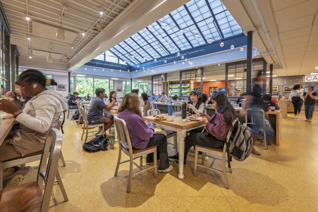 Students sitting at tables in a dining hall.