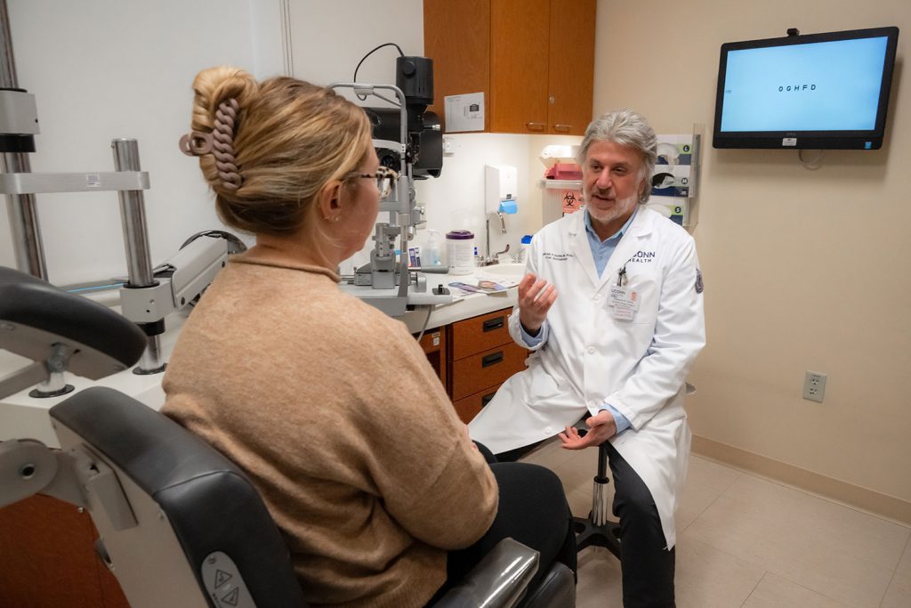Dr. Edmund Farris speaking to female patient in exam room