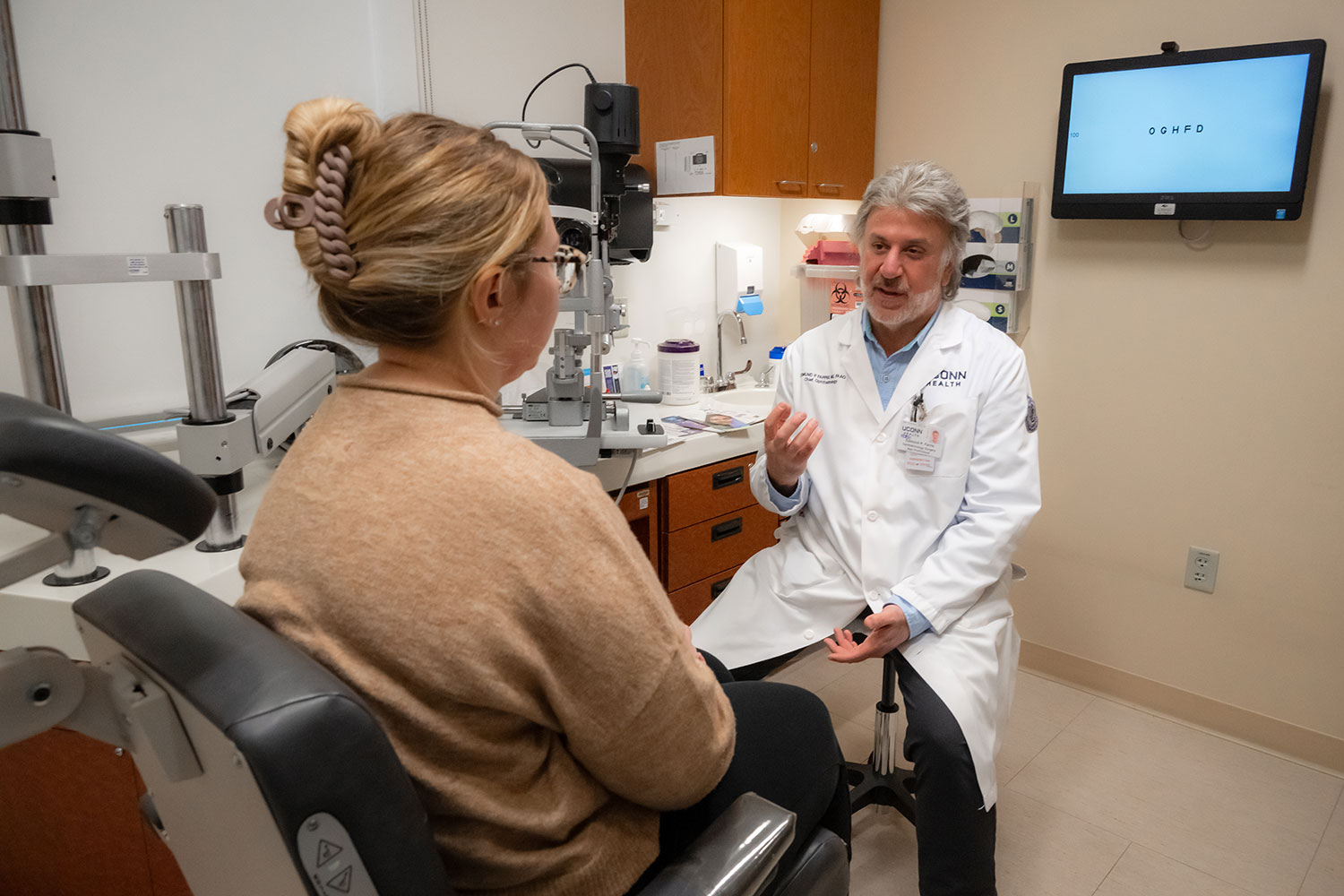 Dr. Edmund Farris speaking to female patient in exam room