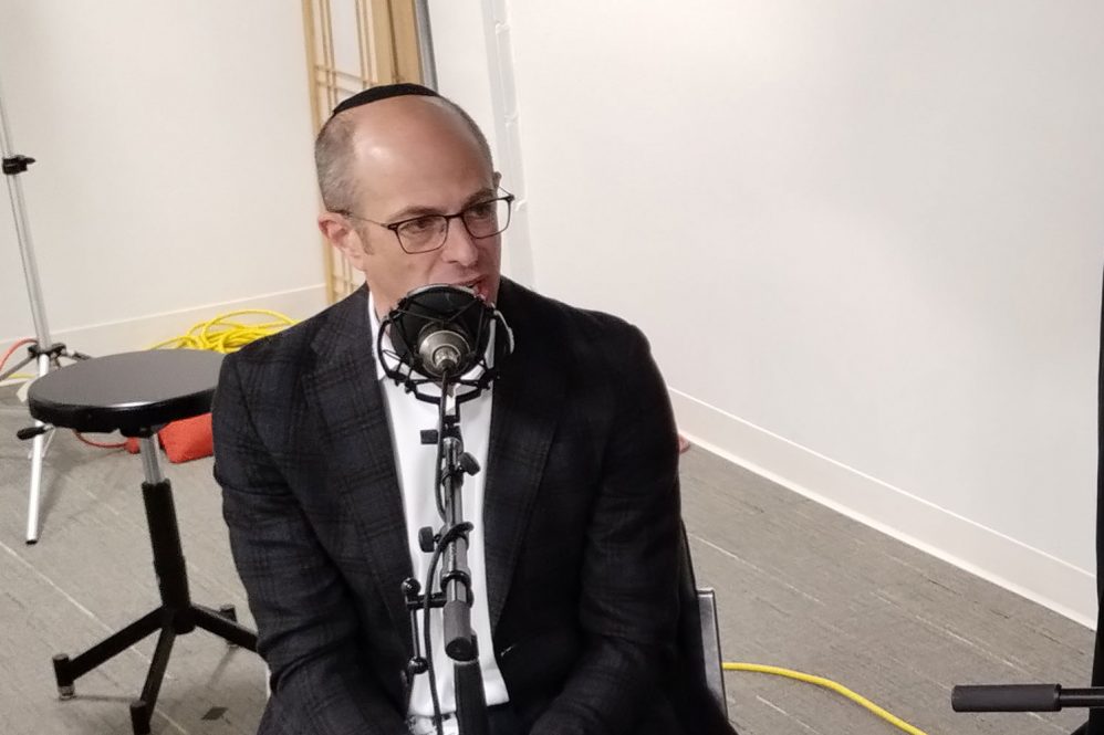 Dr. Isaac Moss at microphone in studio