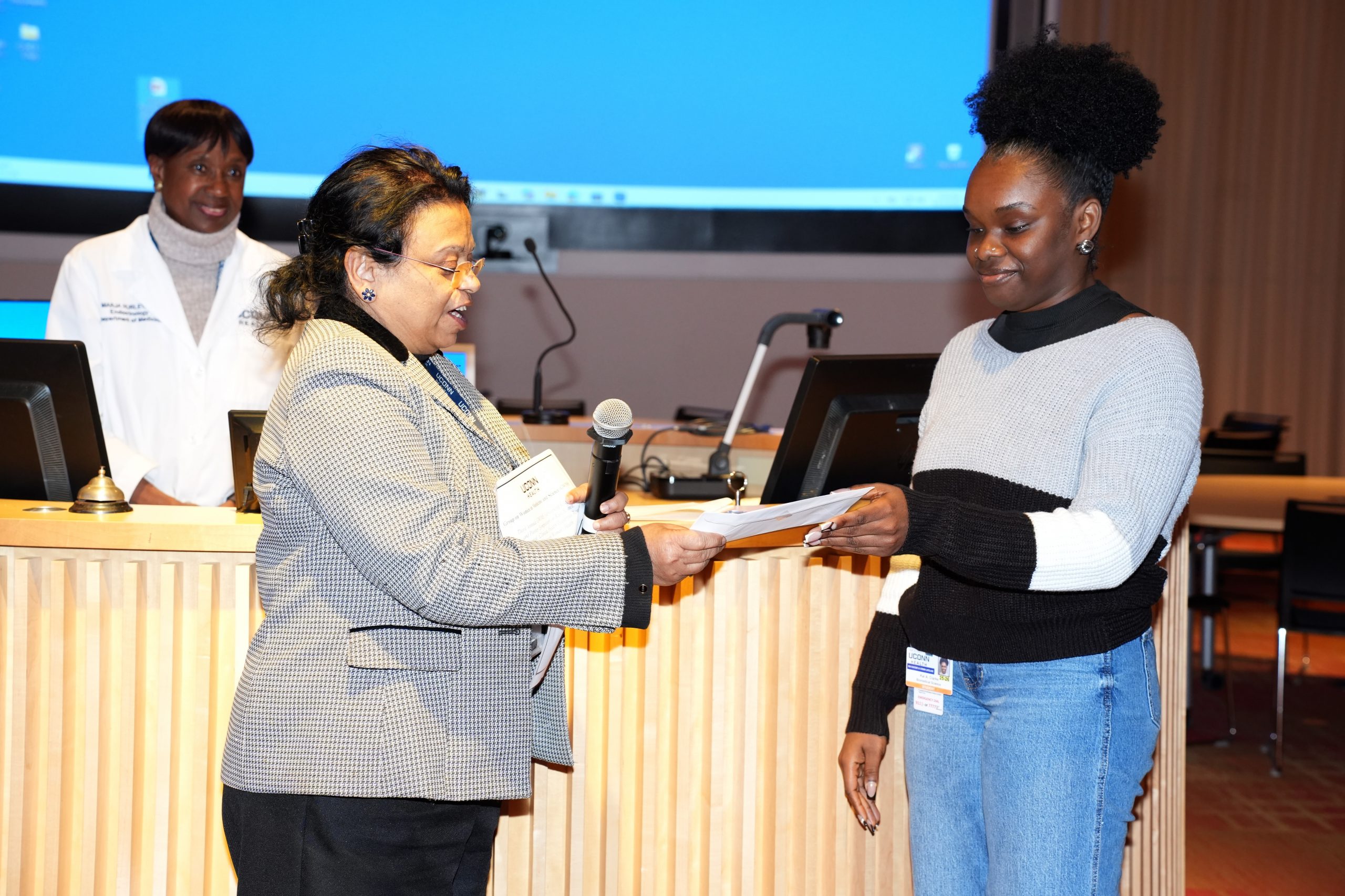 Kai Clarke being honored as the winner of the best poster in the basic science/translational research category by Dr. Nilanjana Maulik, Ph.D.