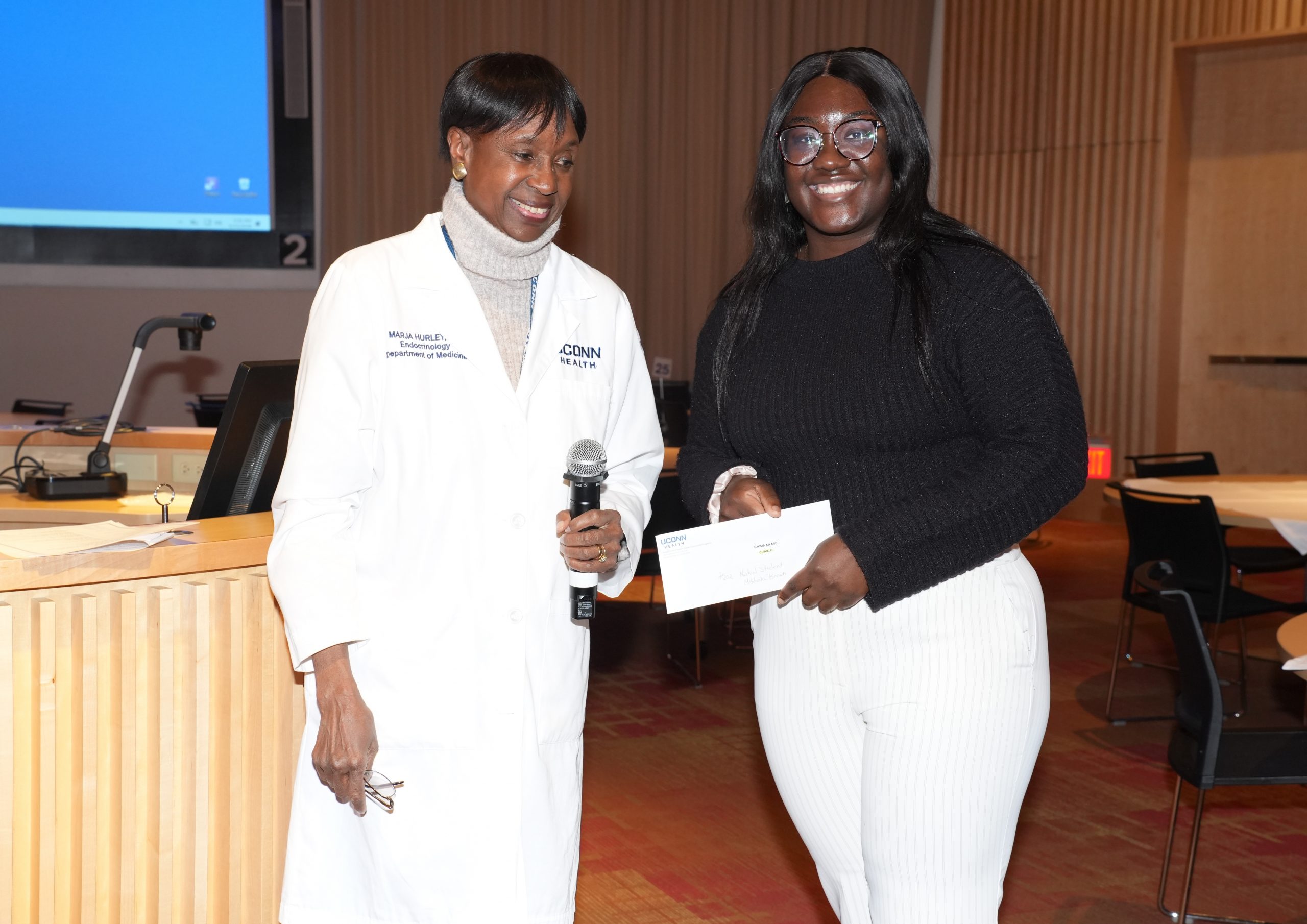 Resident Dr. Charissa Joy Okang represented the winning research team awarded for the best poster in the clinical category by Dr. Marja Hurley. (Photo by John Atashian)
