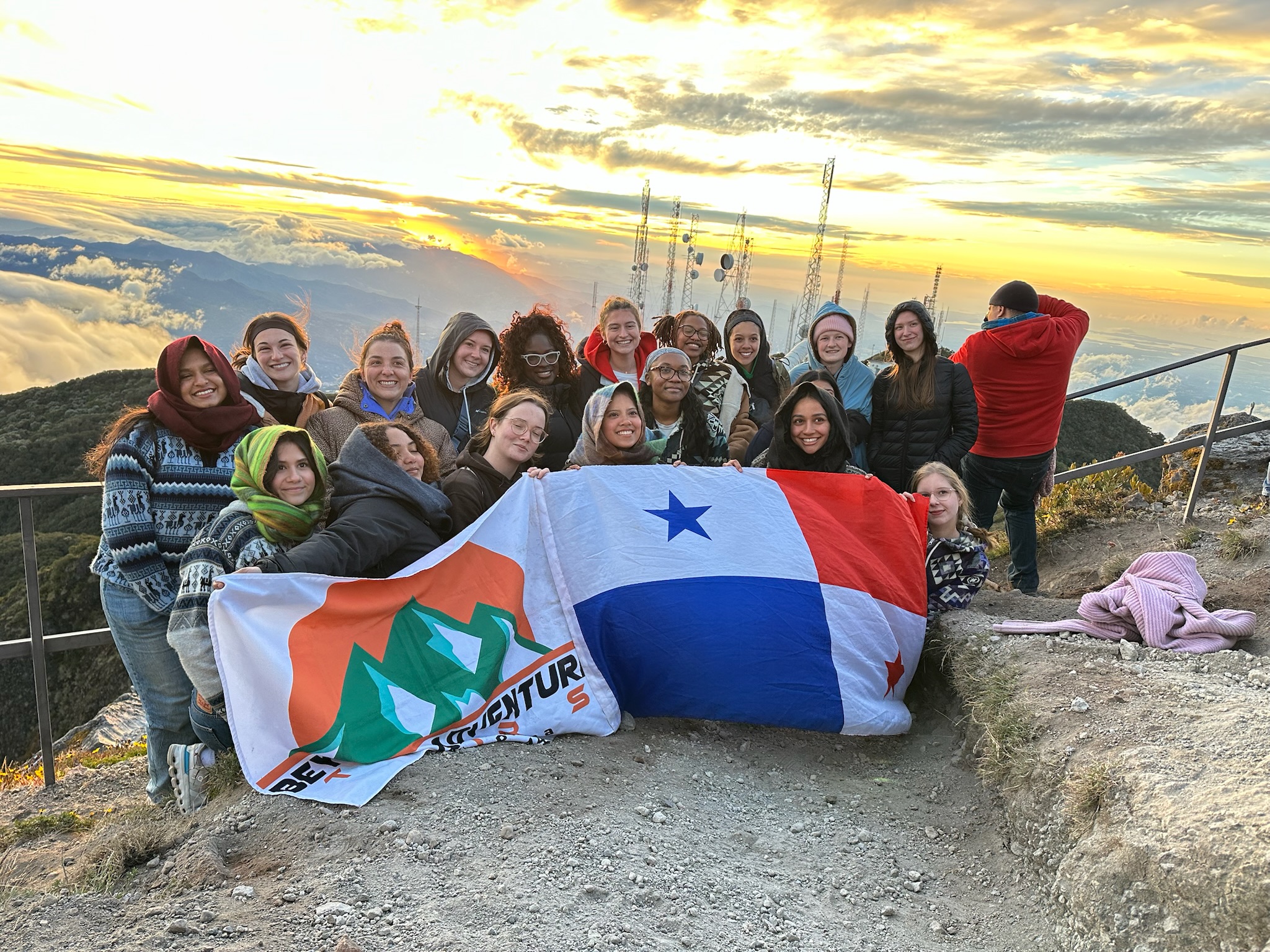 A group of young people posing behind a Panamanian flag.