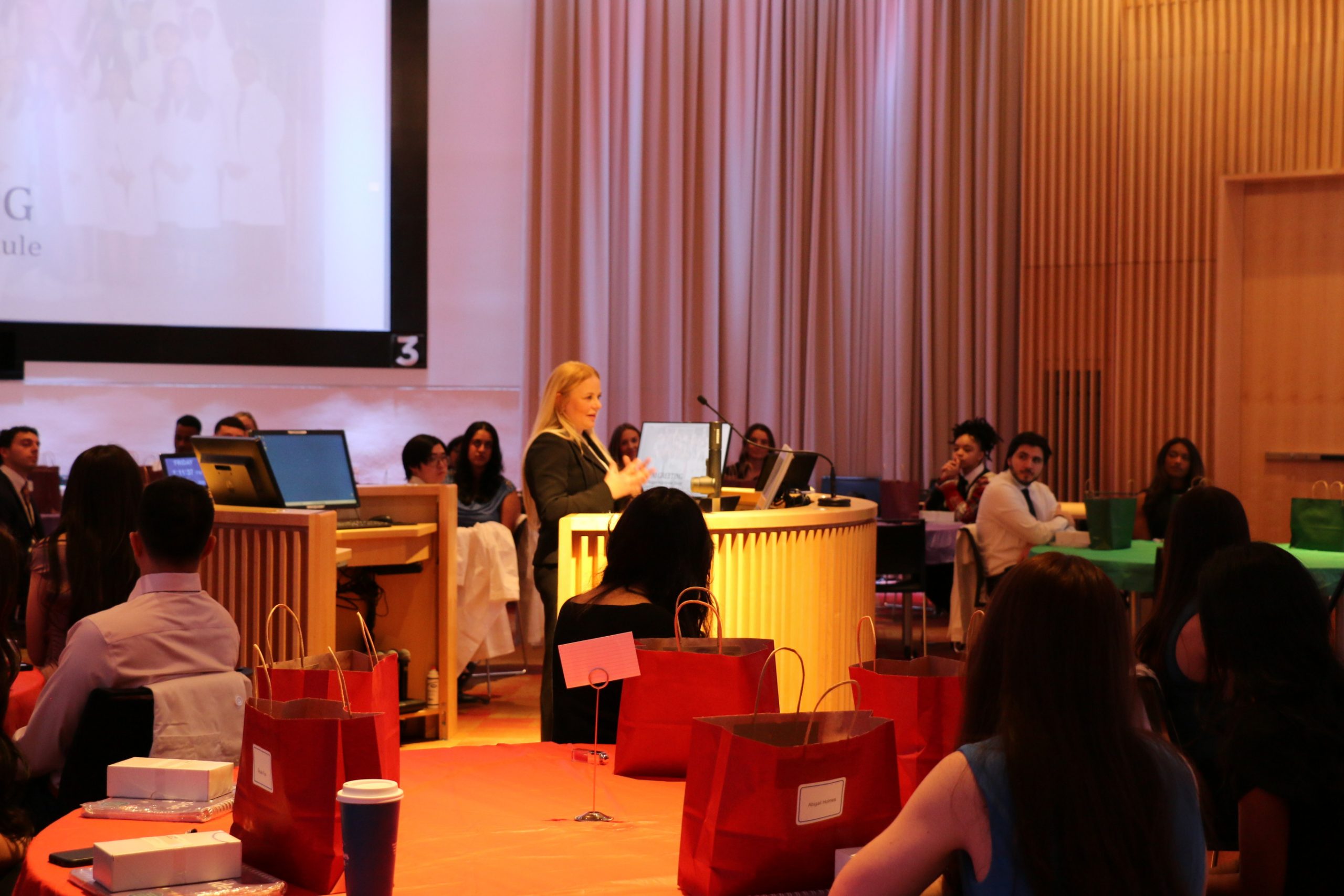 female speaks to audience of students