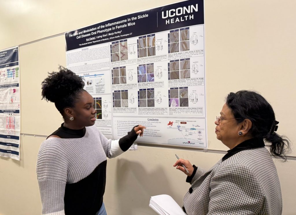 Grad student Kai Clarke presenting her poster to judge.