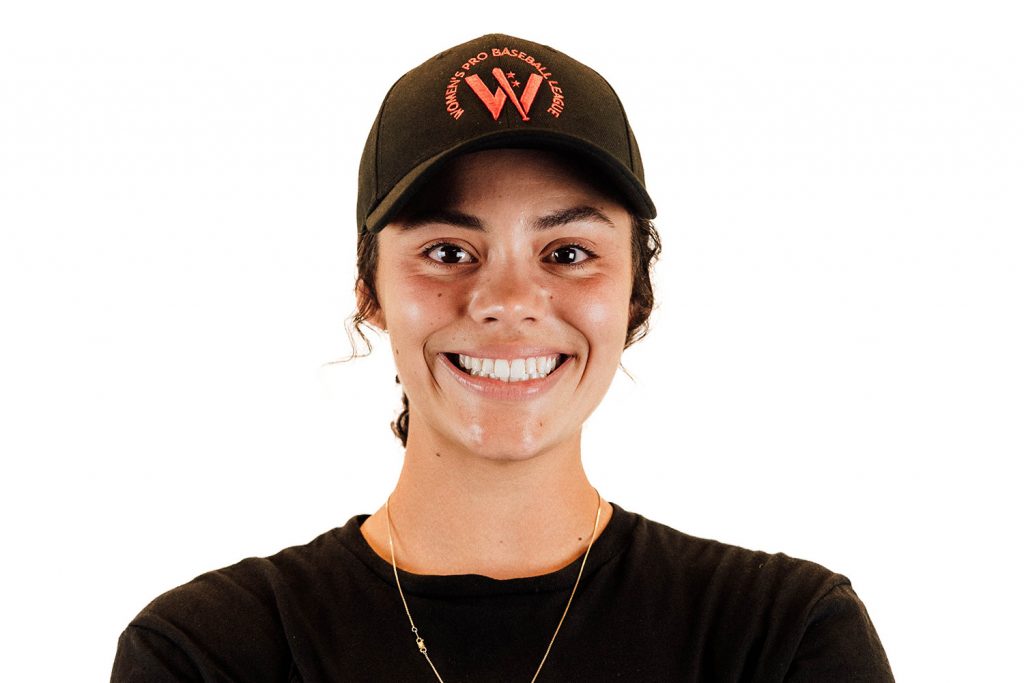 A woman smiling wearing a baseball cap