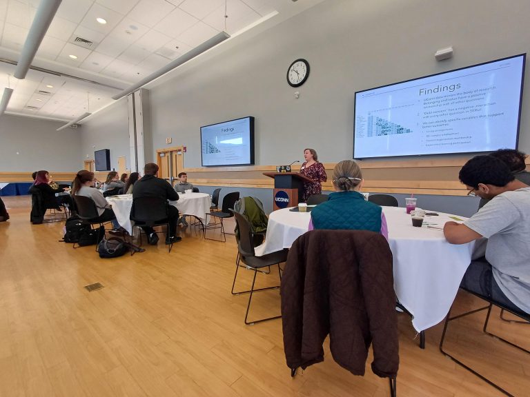 Tables of people listening to a speaker at a podium