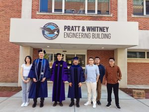 A group photo of students and faculty outside the Pratt & Whitney Engineering Building.