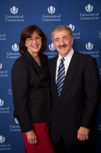 Sally Reis and Joseph Renzulli in formal attire in front of a University of Connecticut backdrop