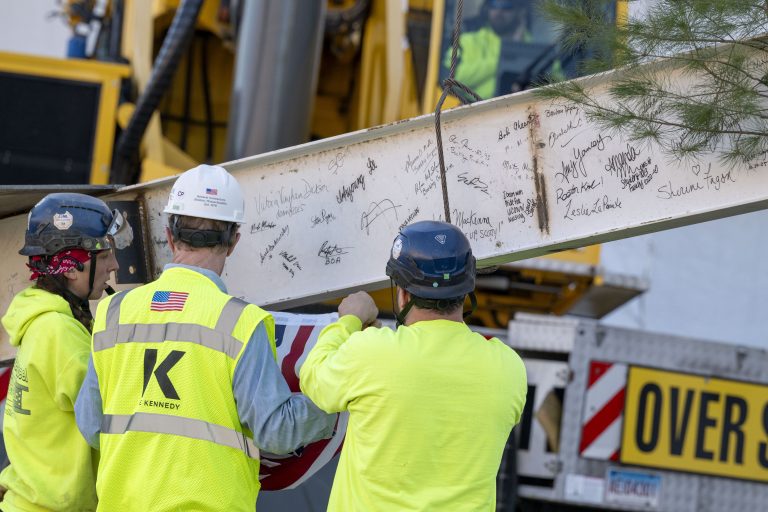 Construction workers for DeLuca Hall with the signed beam.