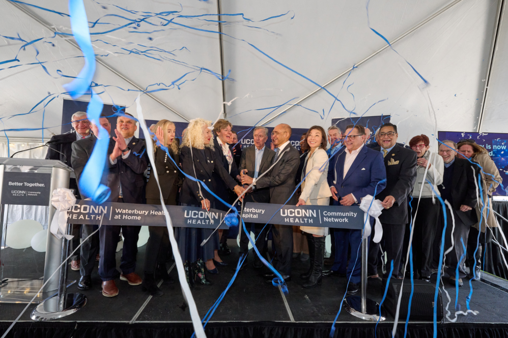 group of men and women cutting a ribbon