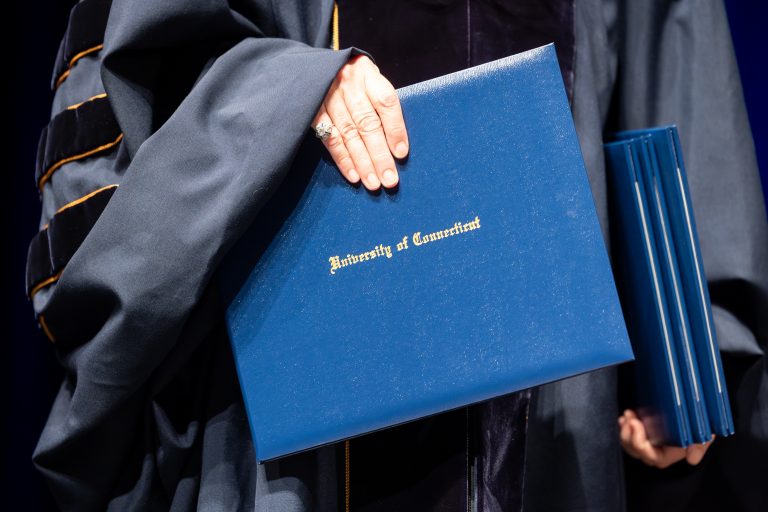 A hand holding a diploma that says 