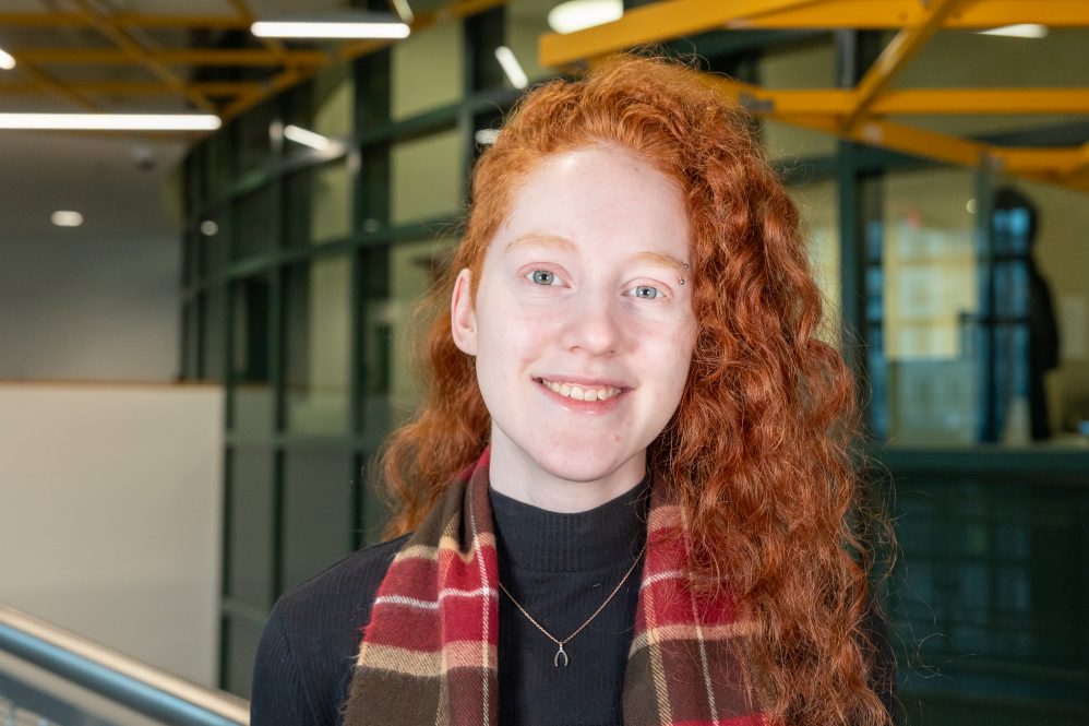 A girl with red, curly hair poses for a photo