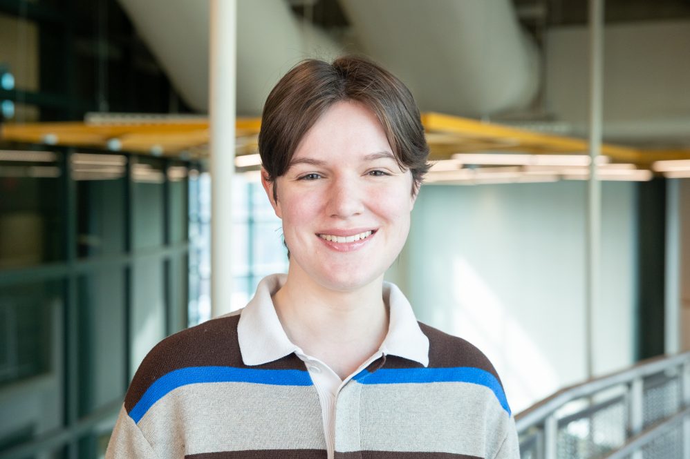A woman in a polo shirt poses for a photo