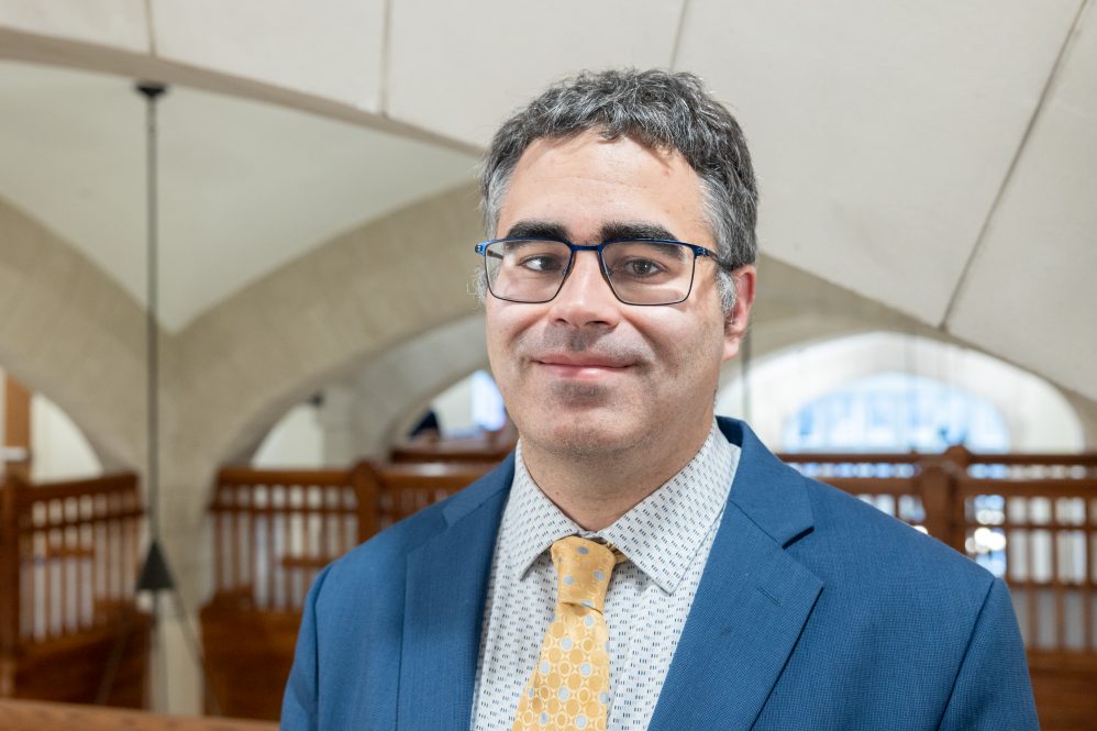 A man in a suit with glasses posing for a photo