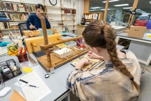 A woman working on preserving a book in a library