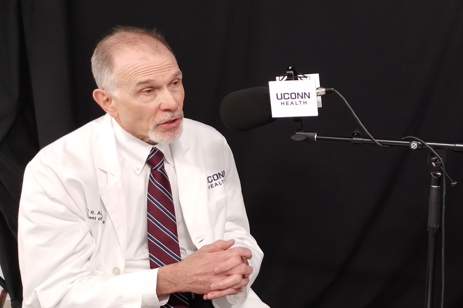 Dr. Scott Allen speaking at microphone in podcast studio