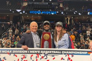 portrait three people with NCAA regional final trophy