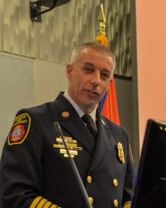 Fire Chief Chris Renshaw in dress uniform speaking at podium