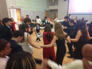 People holding hands and dancing in a circle.