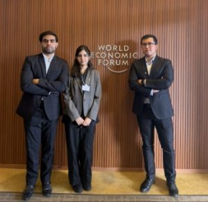 Two men and one woman posing for a photo in suits