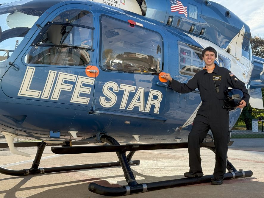 Justin Pedneault, RN, CFRN, FP-C, pictured next to a LIFE STAR helicopter.