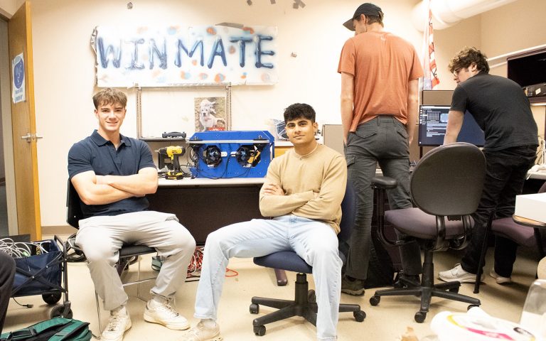 Colin Sheardwright and Krish Buva sit side by side in a lab.
