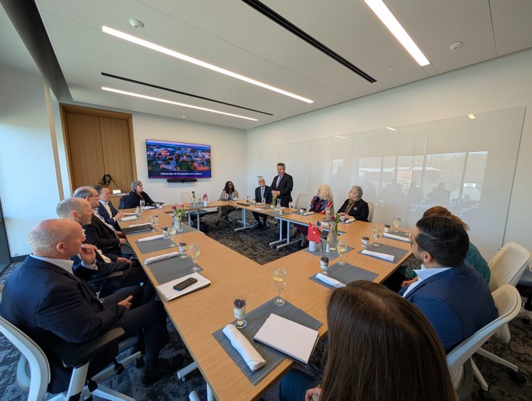 People sitting around a rectangular table in a meeting room.