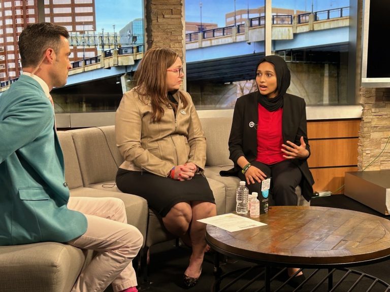 Three people sitting side by side as a panel on a TV talk show.