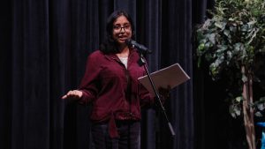A girl stands at a microphone giving a performance.